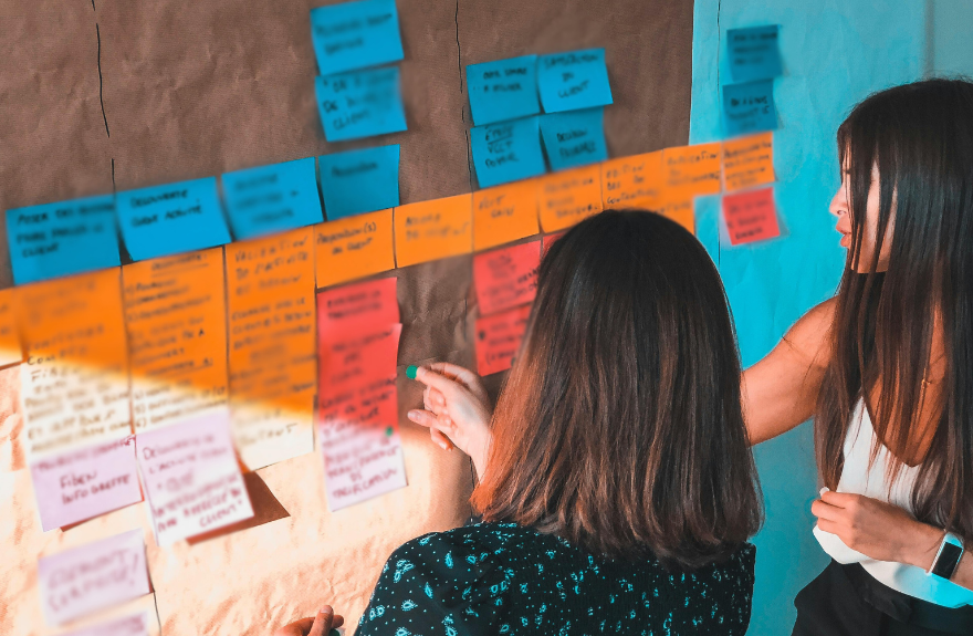 Dos personas colocando post it en una pared