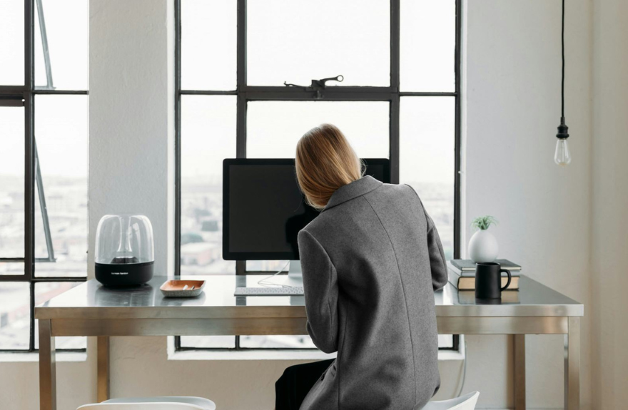 Persona trabajando en un escritorio vestida con traje de chaqueta gris