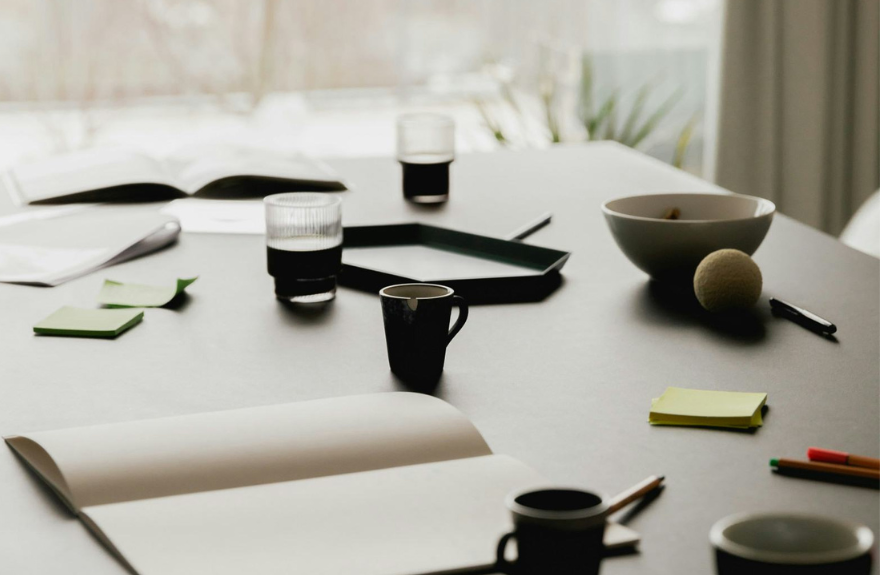 Mesa con tazas de café y blocs de notas en una reunión